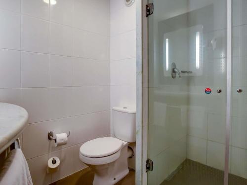 a white bathroom with a toilet and a shower at ibis Rio de Janeiro Santos Dumont in Rio de Janeiro