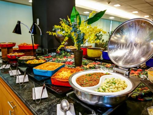 a buffet with many different types of food on a counter at ibis Rio de Janeiro Santos Dumont in Rio de Janeiro