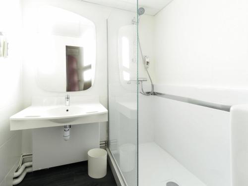a white bathroom with a sink and a shower at ibis Rouen Centre Champ de Mars in Rouen