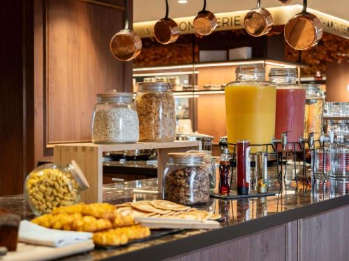 a kitchen with a counter with some food and drinks at ibis Rouen Centre Champ de Mars in Rouen