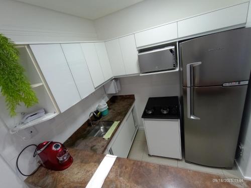 a small kitchen with a stainless steel refrigerator at Apart Atlantic City Service Ondina in Salvador