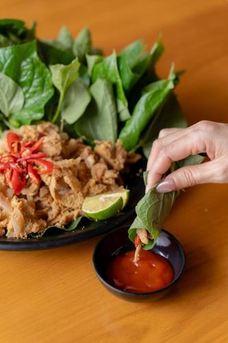 a person dipping a lime into a plate of food at Gia Trang Heian Hoa Binh in Hòa Bình