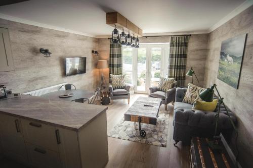 a kitchen and living room with a couch and a table at Kirklea Island Suites in Tarbert
