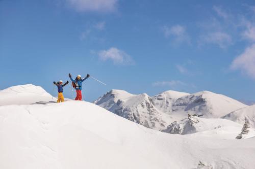 two people standing on top of a snow covered mountain at Aldiana Club Salzkammergut und GrimmingTherme in Bad Mitterndorf