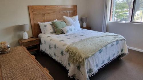 a bedroom with a bed with a wooden headboard at Lazy Dayz On Booner! in Hawks Nest