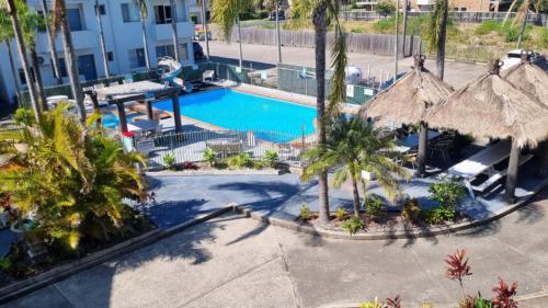 an overhead view of a pool with palm trees and umbrellas at Lazy Dayz On Booner! in Hawks Nest