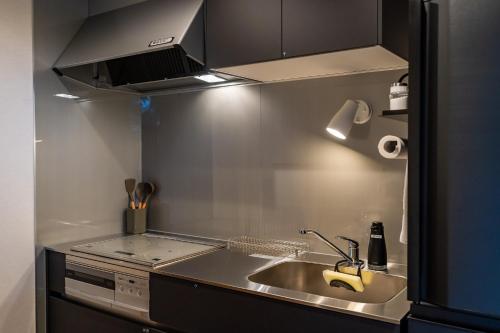 a small kitchen with a sink and a stove at SETO CLAS for SLEEP B棟 in Takamatsu