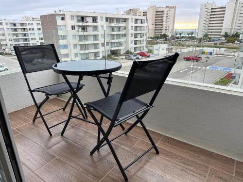 two chairs and a table on a balcony at Dpto con terraza vista al mar y faro in La Serena