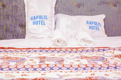 a bed with two pillows and towels on it at Rapolis Hotel Keroka in Keroka