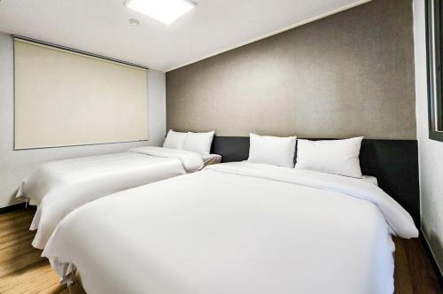 two beds sitting next to each other in a room at Whinstone Hotel & Resort in Jeju