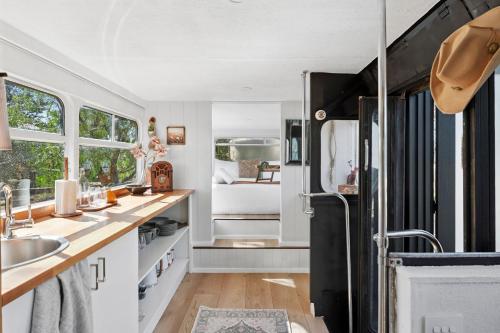 a kitchen with a black refrigerator and white cabinets at Bus Life Sleep Play & Farm Views in Fyansford