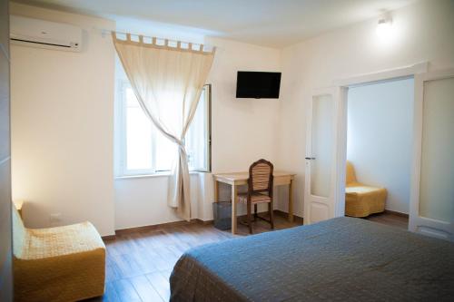a bedroom with a bed and a desk and a window at Le Tre Chiavi in Castelfrentano