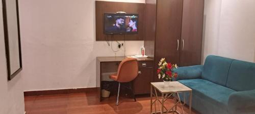 a living room with a blue couch and a tv at SBS Hotel Underbridge in Jāmb