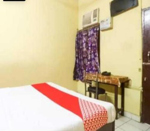 a room with a bed and a desk and a table at Hotel Maharaja Palace in Lucknow