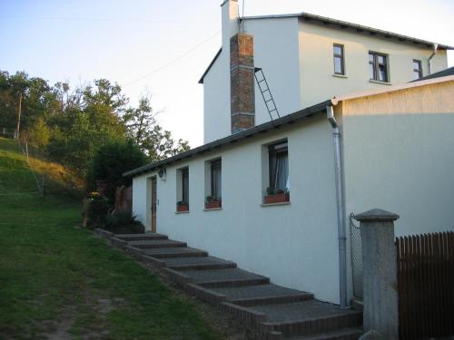 a white house with stairs leading up to it at Ferienwohnungen "Am Mühlteich" in Radeburg