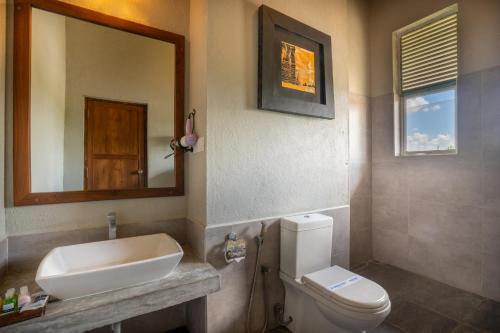 a bathroom with a sink and a toilet and a mirror at Lavendish Wild Wilpattu in Nochchiyagama