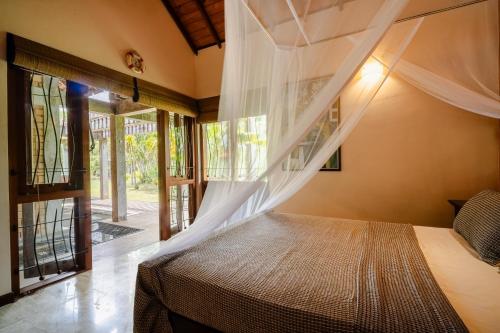 a bedroom with a bed with a mosquito net at The Pier House in Panadura
