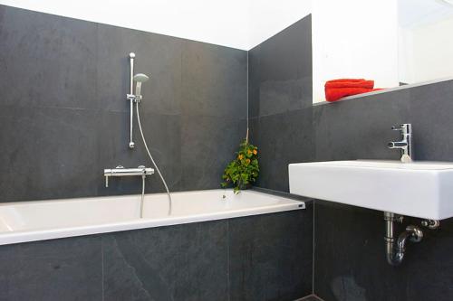 a bathroom with a sink and a bath tub at Spacious Studio Apartment Friedrichshain in Berlin