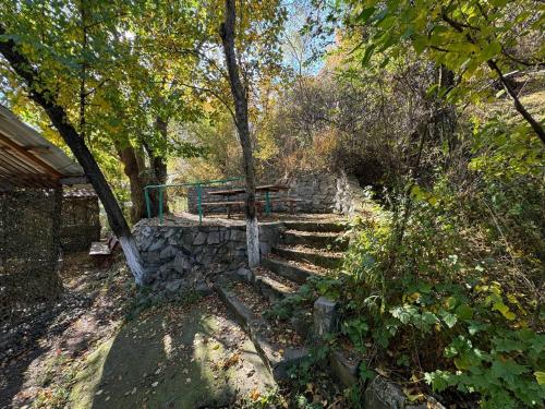 a wooden bench sitting on a stone staircase in a forest at Timur Resort Turgen in Taūtürgen