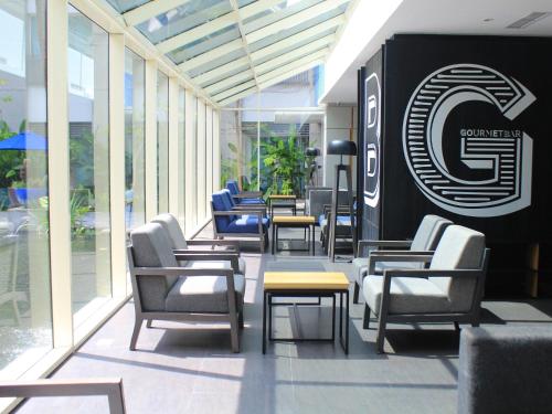 a group of chairs and tables in a lobby at Novotel Jakarta Mangga Dua Square in Jakarta