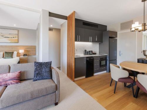 a living room and kitchen with a couch and a table at Peppers Hunter Valley AVC Apartment in Rothbury