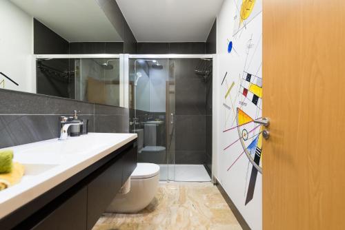 Suites Garden Loft Kandinsky في لاس بالماس دي غران كاناريا: حمام مع مرحاض ومغسلة ودش
