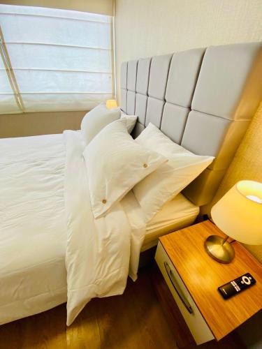 a bedroom with a bed with white pillows and a table at San Miguel Apartment Vista Mar in Lima