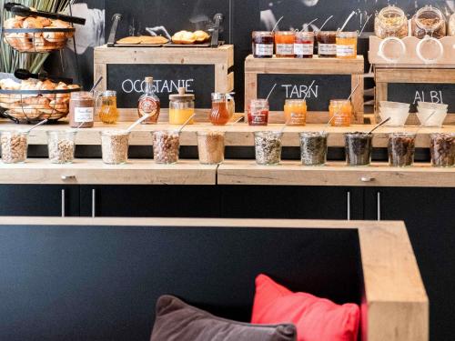 a display of food in jars on a shelf at Ibis Albi in Albi