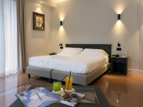 a hotel room with a bed and a table at Mercure Palermo Centro in Palermo