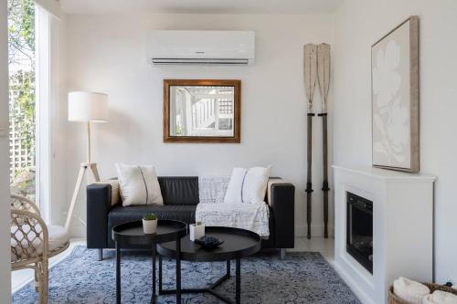 a living room with a couch and a fireplace at Creekhouse by the Sea - Private Jetty and Serene Views in Frankston East
