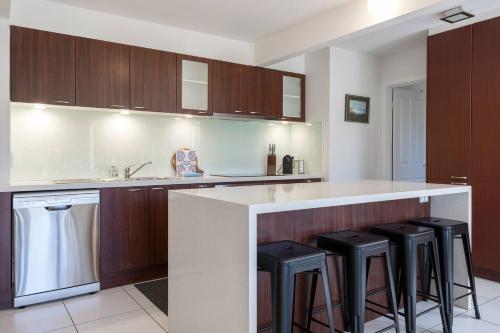 a kitchen with a counter and bar stools at Creekhouse by the Sea - Private Jetty and Serene Views in Frankston East