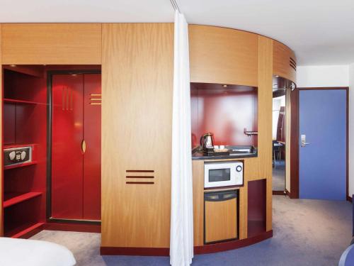 a small kitchen with wooden cabinets and a stove at Novotel Suites Nancy Centre in Nancy