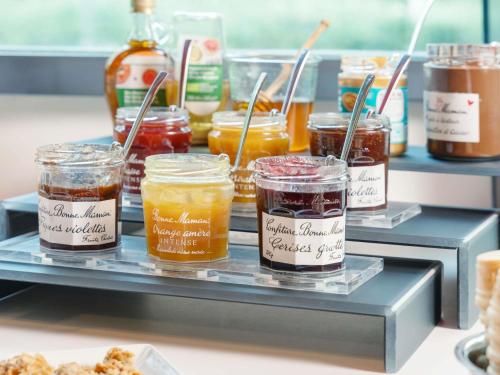 a display of jars of honey on a shelf at Novotel Suites Nancy Centre in Nancy