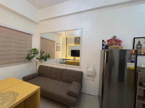 a living room with a couch and a refrigerator at Near Mactan International airport Condo with Private Entrance and Shared Pool in Gun-ob