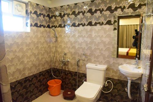 a bathroom with a toilet and a sink at Hotel Lily Inn in Bhubaneshwar
