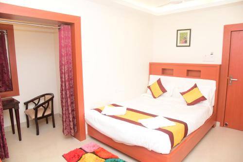 a bedroom with a bed and a table and a chair at Hotel Lily Inn in Bhubaneshwar