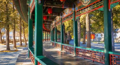 a building with green columns and trees in a park at Beijing Friendship Hotel Jing Bin Building in Beijing
