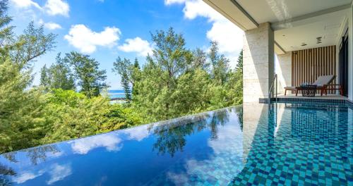 a swimming pool with a view of the ocean from a house at UMITO Okinawa Onnason in Onna