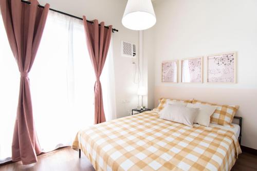 a bedroom with a bed with a checkered blanket at Aston Residences in Manila