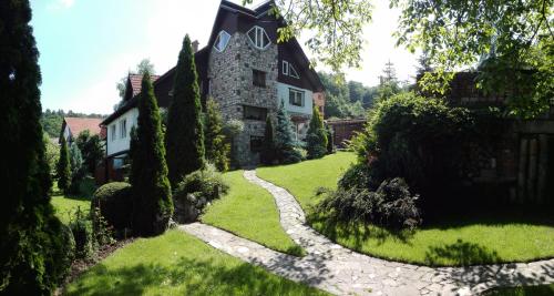 a garden with a stone path leading to a house at Pension Casa Contelui in Râşnov