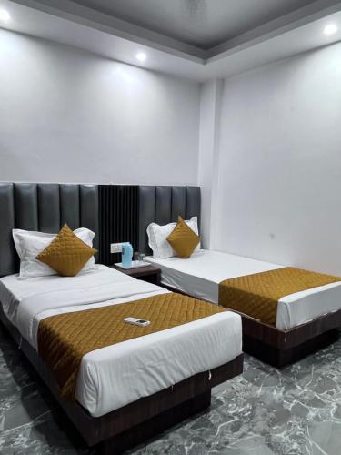 two beds in a hotel room with two beds at Hotel the haveliya-1 mint from new delhi railway station & connaught place in New Delhi