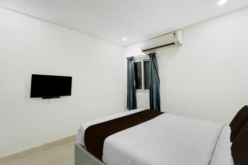 a bedroom with a bed and a flat screen tv at Super Townhouse Nagole RTO Office in Upal