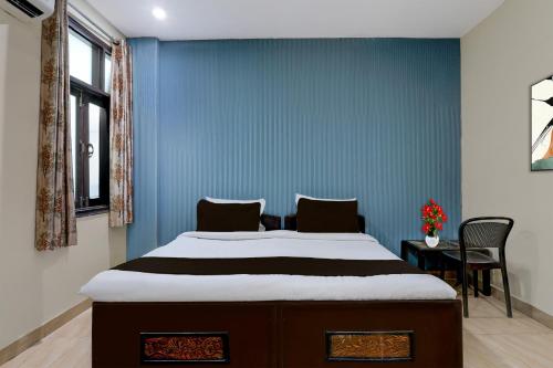 a bedroom with a large bed with a blue wall at Hotel O Faridabad Central Railway Junction Formerly Diamond in Faridabad