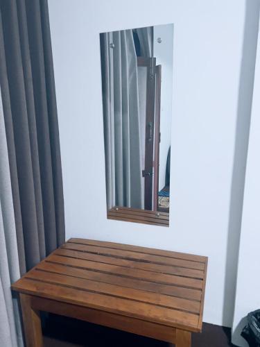 a mirror and a wooden bench in a room at Kithaya Ella in Ella