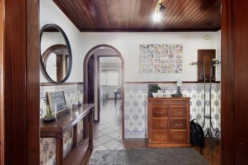 a bathroom with a wooden dresser and a mirror at Live Vagueira Beach in Praia da Vagueira