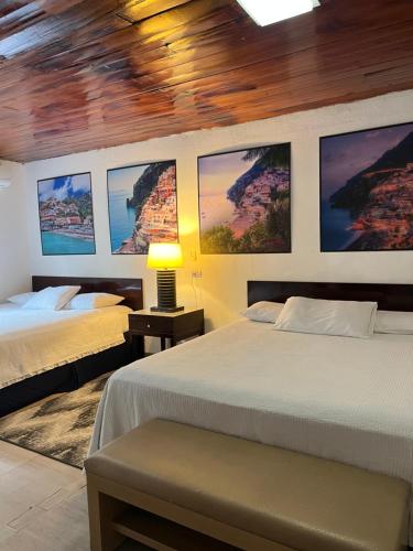 a bedroom with two beds and pictures on the wall at VILLA NAPOLI in Santa Ana