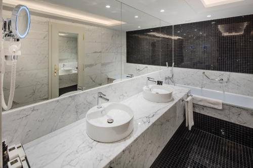 a bathroom with two sinks and a large mirror at Hotel Savoy Prague in Prague