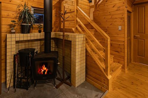 a brick fireplace in a room with a staircase at オーシャンヴィラ Breeze and Dog in Yokosuka