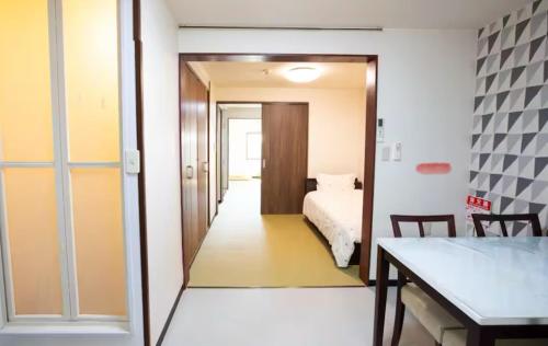 a room with a bedroom with a bed and a table at サンハウス 2 in Osaka