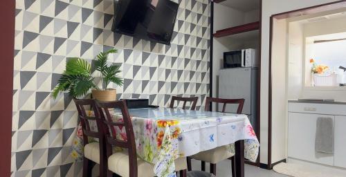 Una cocina con una mesa y sillas en una cocina. en サンハウス 2, en Osaka